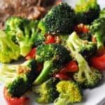 Cooked broccoli and red pepper on plate ready to eat.