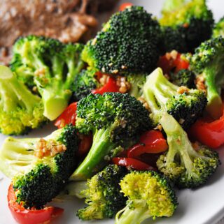 Cooked broccoli and red pepper on plate ready to eat.