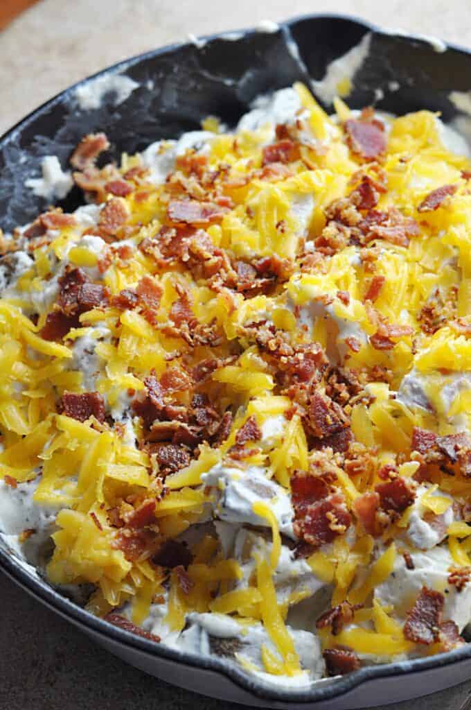 Bacon Ranch potatoes covered in cheese and bacon ready for the oven