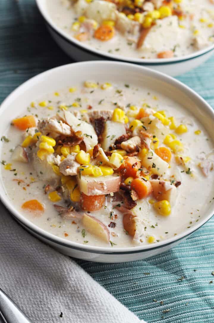 Corn soup with chicken, potatoes, and carrots in bowl