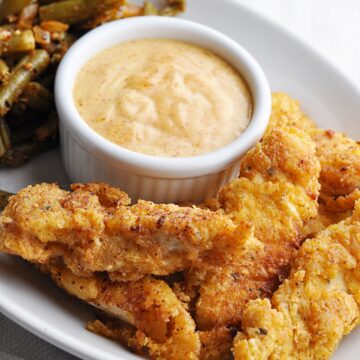 Buttermilk chicken strips served with paprika dipping sauce and green beans.