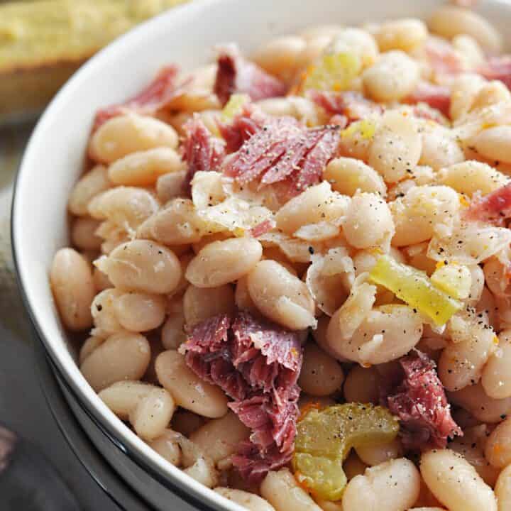 Great northern beans with ham close up in bowl