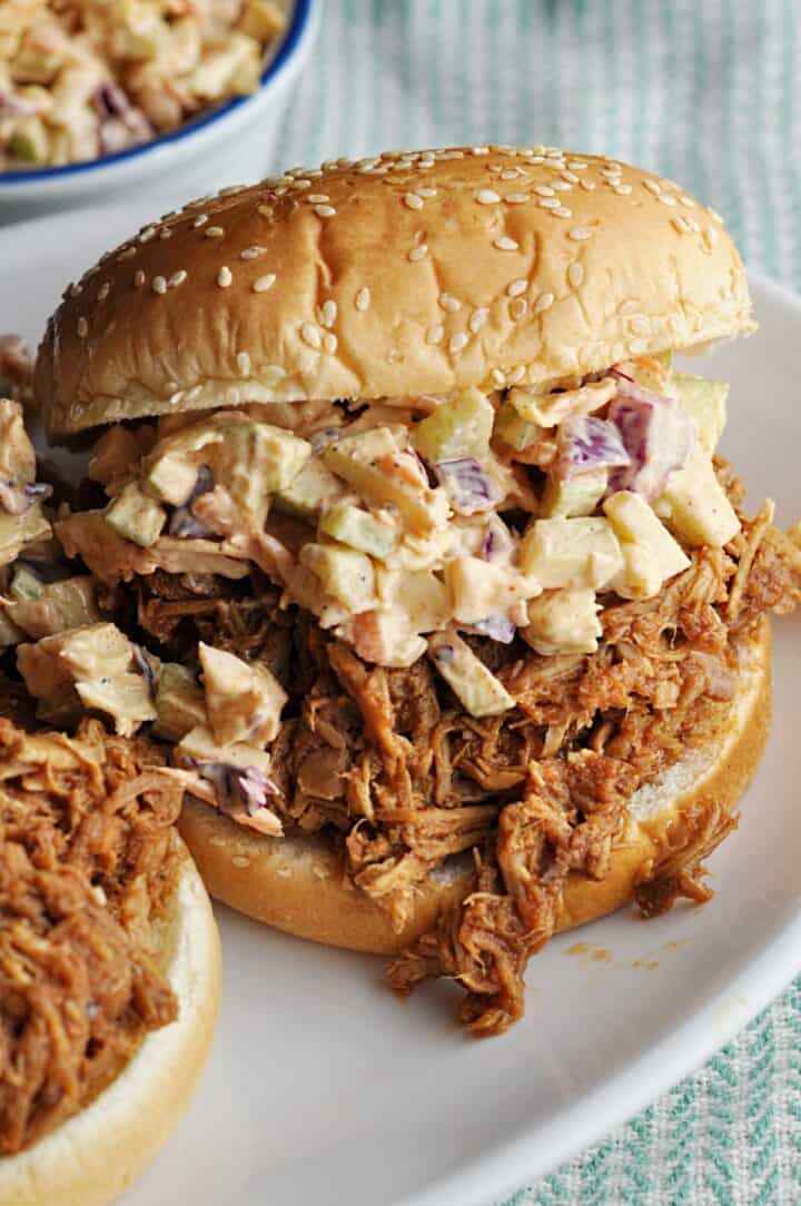 Apple slaw on top of pulled pork on bun