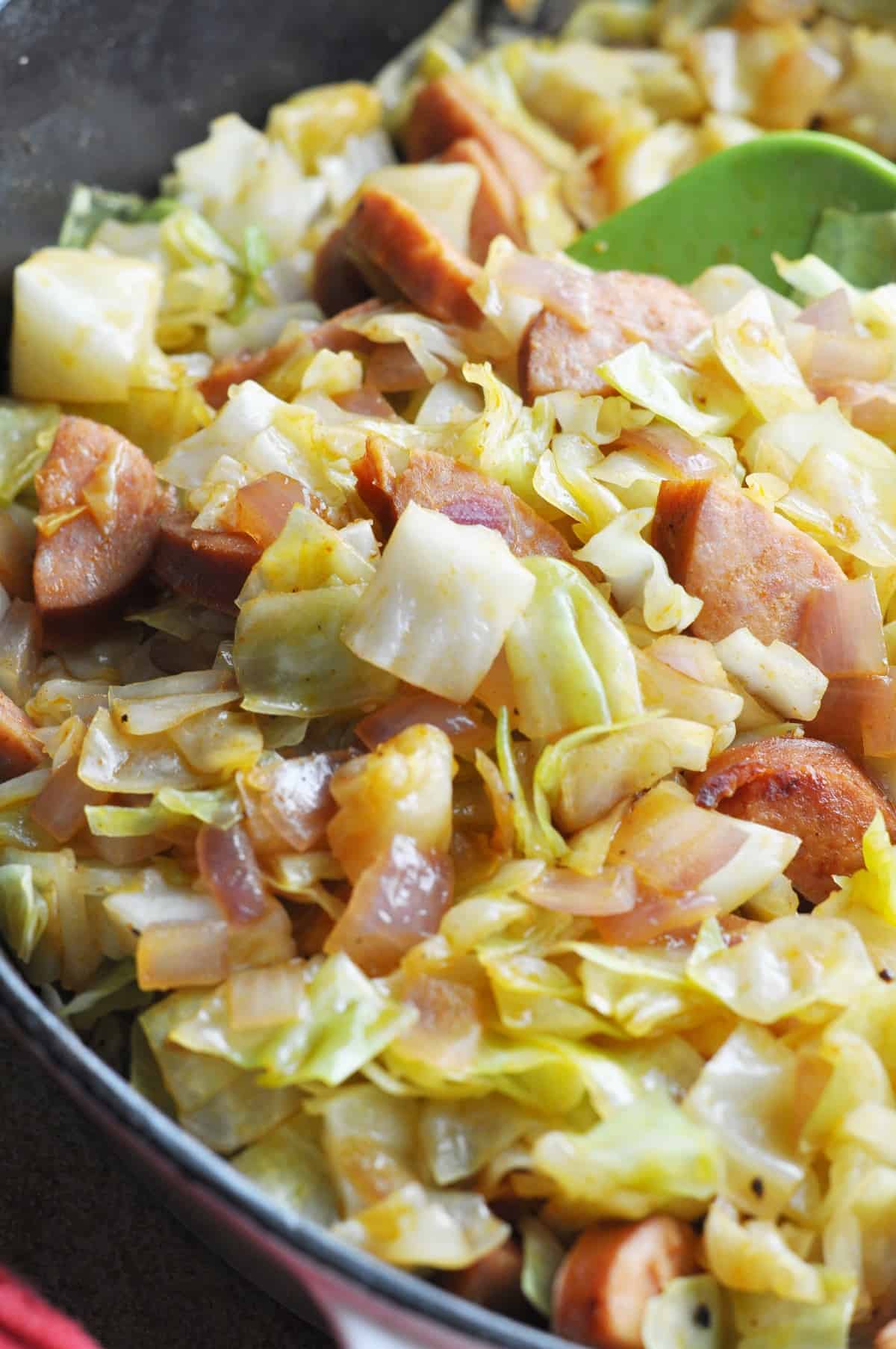 Southern fried cabbage cooking in heavy skillet