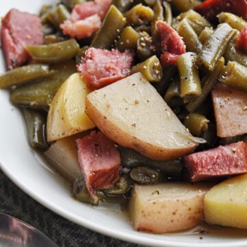 Green beans and potatoes with ham chunks on plate