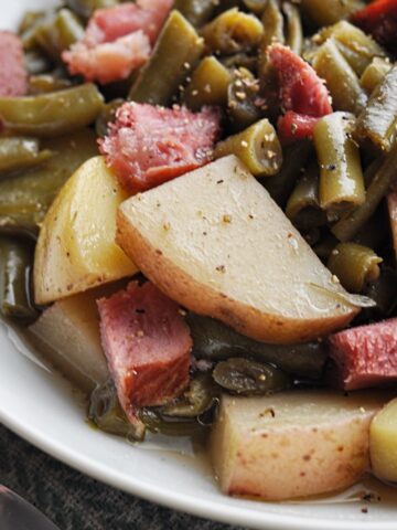 Green beans and potatoes with ham chunks on plate