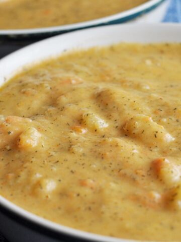 Close up of potato soup in bowl with leeks and carrots