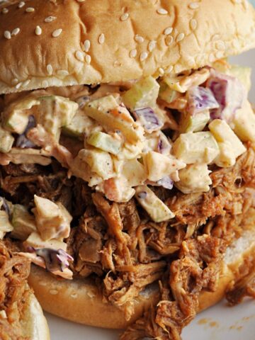 Pulled pork sandwich with apple slaw on sesame seed bun