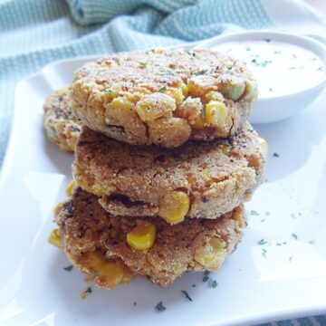 Corn fritters on a plate with dipping sauce