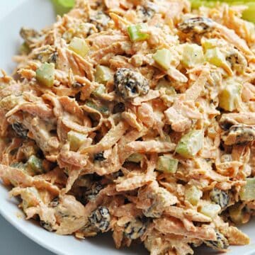 Carrot raisin salad with celery in bowl ready to serve.