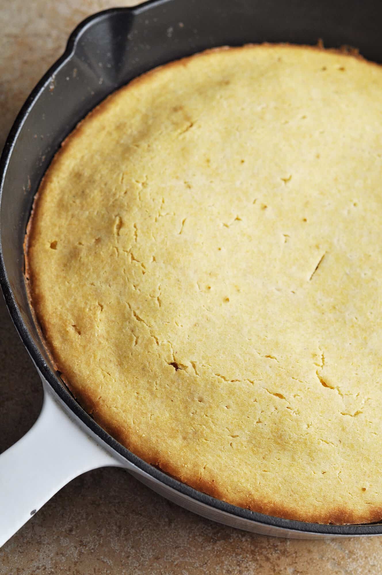 Cooked cornbread in cast iron skillet.