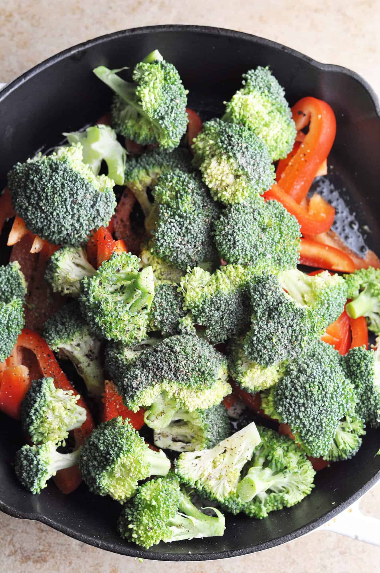Broccoli and red peppers in cast iron skillet ready to cook.