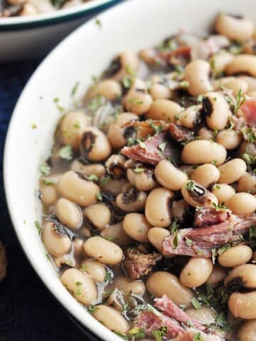 Cooked black eyed peas with ham served in bowl.