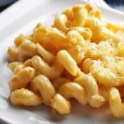 Close up of pasta with melted cheese on a plate.